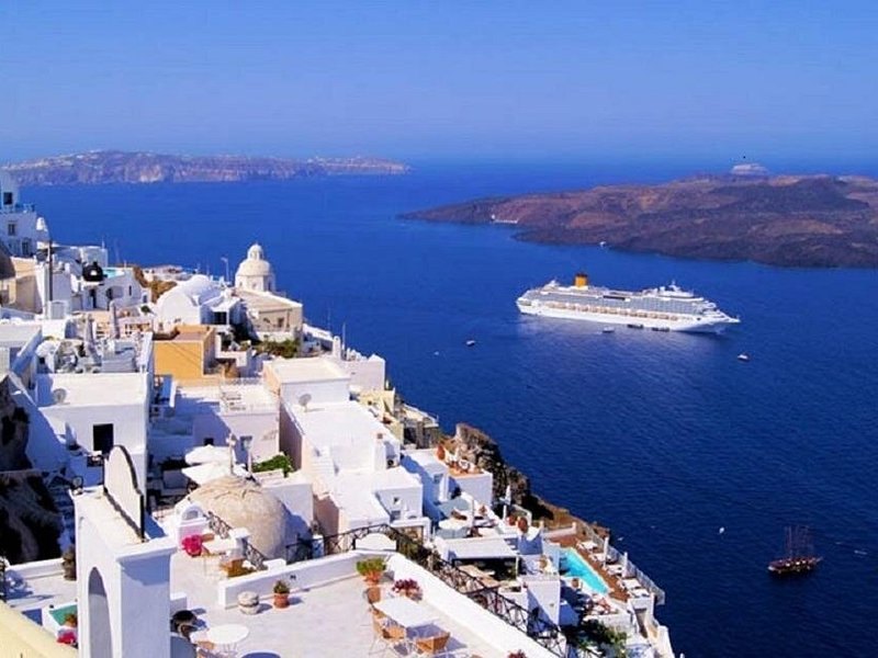 A cruise ship anchored in the caldera below the cliffs of Fira