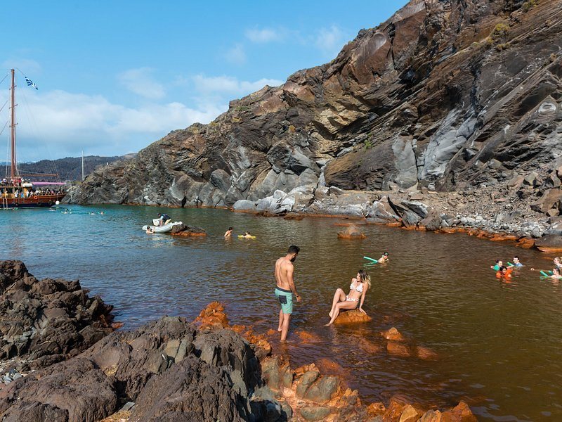 Swimmers in the warm shallow cove at the Palea Kameni hot springs