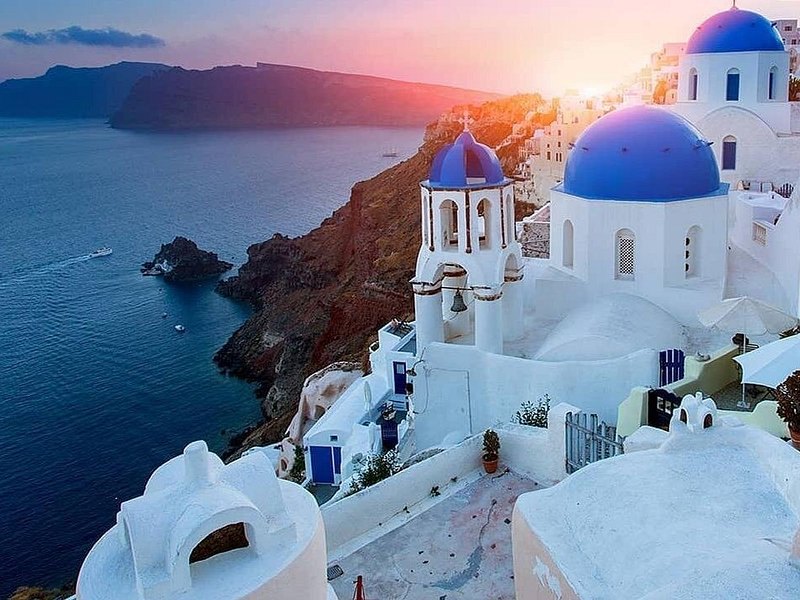 The domes of Oia in late-afternoon light above the Aegean