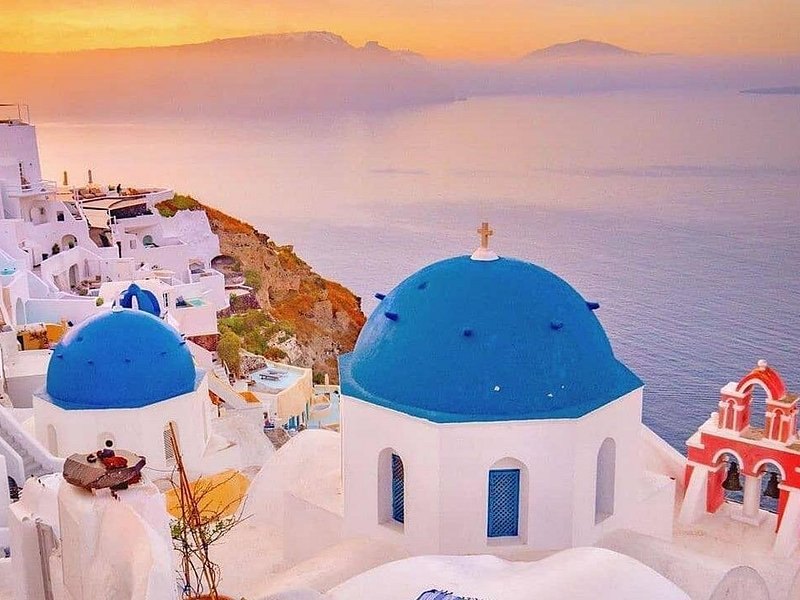 The three domes of Oia photographed at golden hour